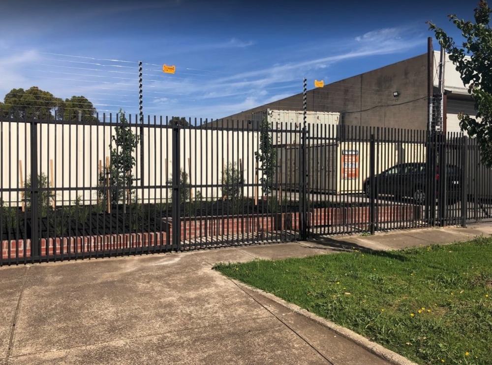 The front fence and gate at Sunshine Self Storage, 15 Carrington Drive, Albion, with shipping containers behind